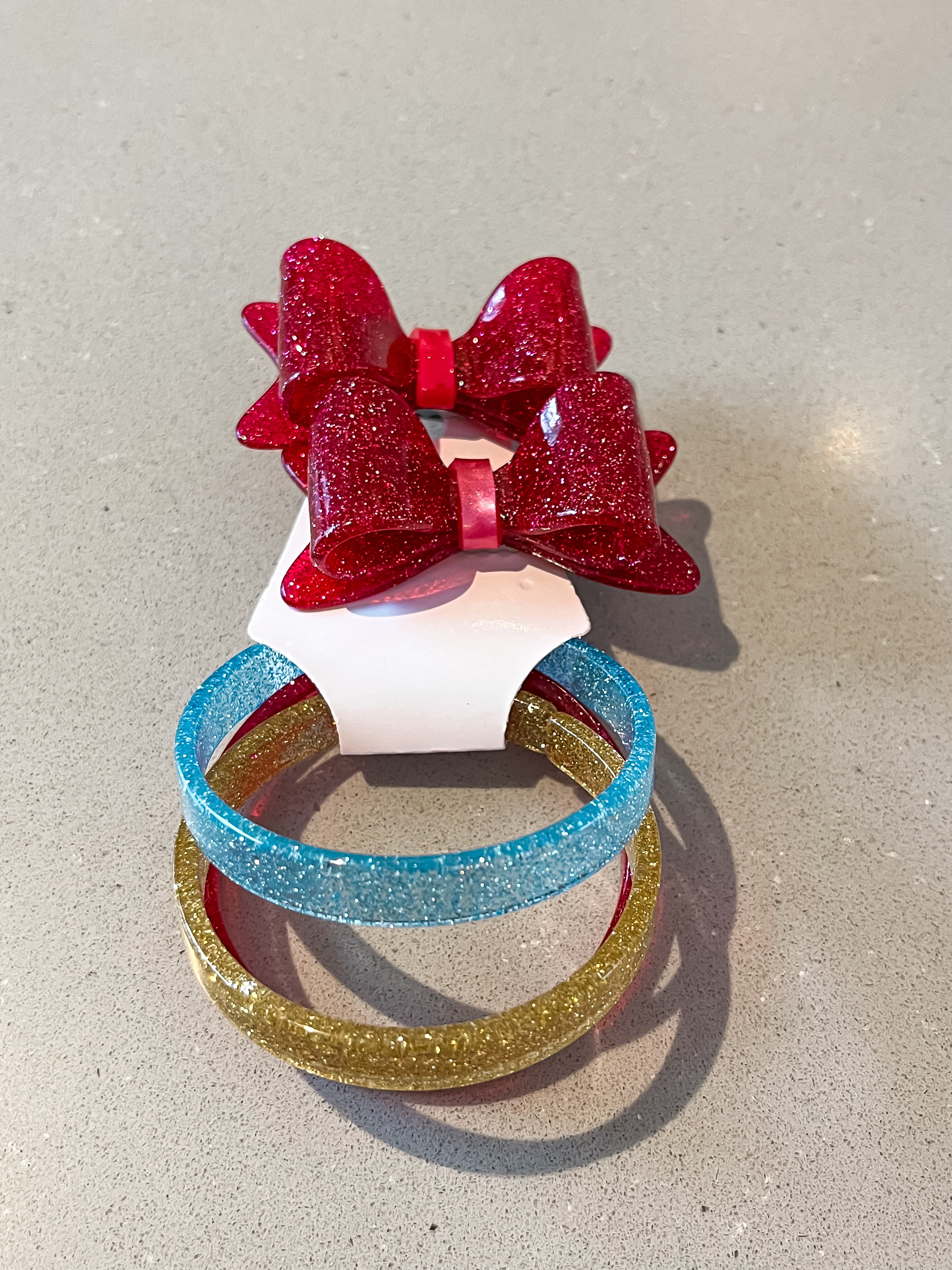 Dark pink sparkly acrylic bow hair clip with multicolor bracelets